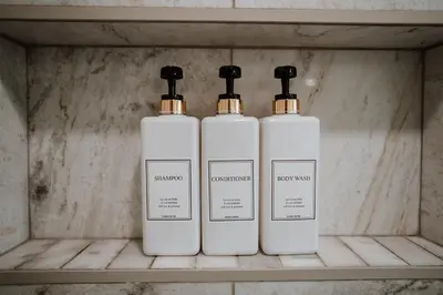 three bottles of soap sitting on a shelf at Modern home w hot tub & game room in Centennial