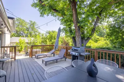 a deck with chairs and a grill and a tree at Modern home w hot tub & game room in Centennial