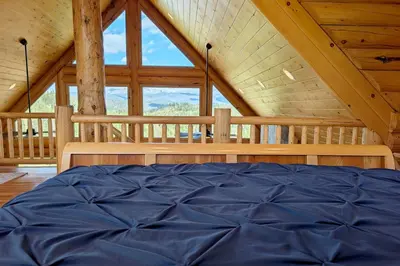 a bedroom with a large window in a cabin at New Log Home, Hot Tub For 8, Views! in Tabernash
