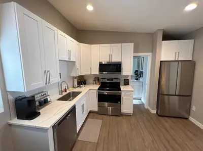 a kitchen with white cabinets and stainless steel appliances at Chic & intimate 2 bedroom in Brighton