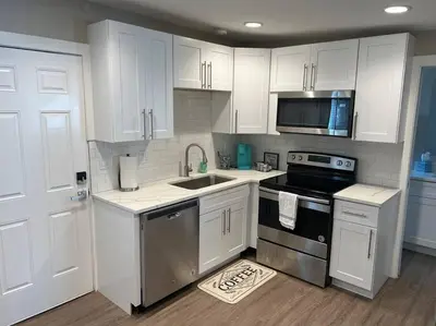 a kitchen with white cabinets and a sink and a stove at Cozy 1 bedroom in the heart of Brighton in Brighton