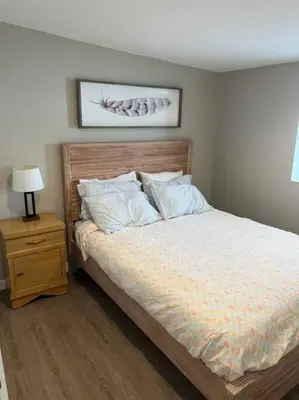 a bedroom with a bed and a night stand with a lamp at Cozy 1 bedroom in the heart of Brighton in Brighton