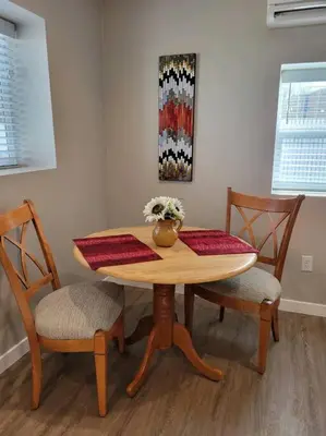 a dining room table with two chairs and a vase with flowers at Calm and relaxing 1 bed in Brighton