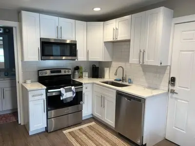 a kitchen with white cabinets and a stove and a sink at Calm and relaxing 1 bed in Brighton