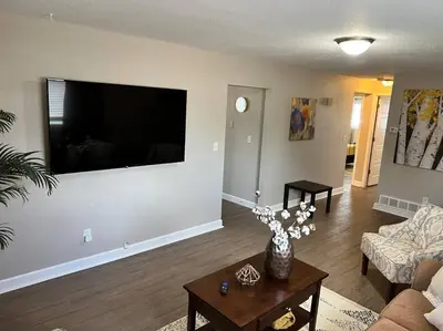 a living room with a large flat screen tv on a wall at Spacious Westminster 2bd/1ba in Westminster