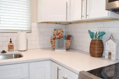 a kitchen counter with white cabinets and a sink at Cozy 3 bedroom in Westminster in Westminster