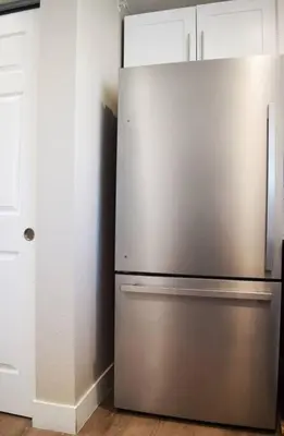 a stainless steel refrigerator in a kitchen with white cabinets at Modern 2 bed in Westminster in Westminster