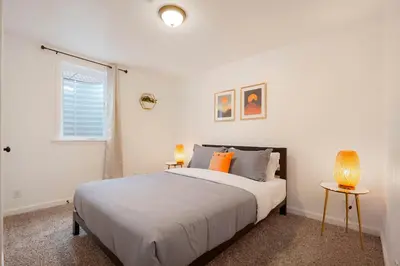 a white bedroom with a large bed and two lamps at Cozy Getaway Retreat - 4BR - Northglenn in Northglenn