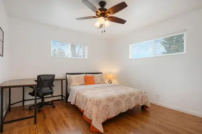 a bedroom with a bed and a desk and a ceiling fan at Cozy Getaway Retreat - 4BR - Northglenn in Northglenn