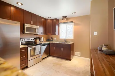 a kitchen with wooden cabinets and a stove top oven at Cozy Getaway Retreat - 4BR - Northglenn in Northglenn