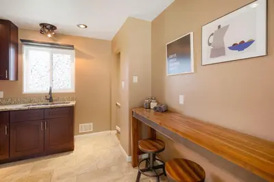 a kitchen with a bar with two stools and a sink at Cozy Getaway Retreat - 4BR - Northglenn in Northglenn