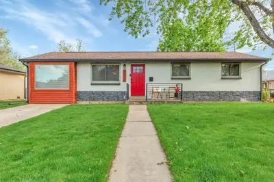 a house with a red door and a grass yard at Backyard BBQ Retreat: Central 3bd - Prime Location in Arvada