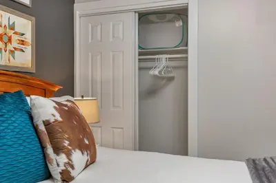 a bedroom with a white bed and a door at Backyard BBQ Retreat: Central 3bd - Prime Location in Arvada