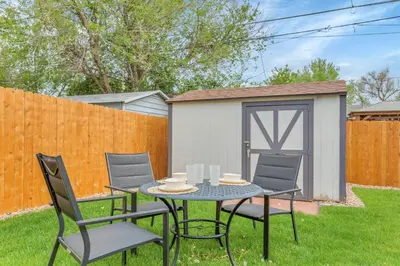 a table and chairs in a yard with a fence at Backyard BBQ Retreat: Central 3bd - Prime Location in Arvada