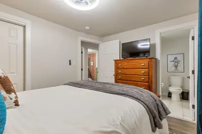 a bedroom with a bed and a dresser with a television at Backyard BBQ Retreat: Central 3bd - Prime Location in Arvada