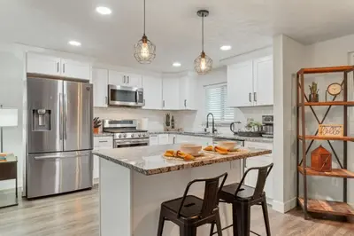 a kitchen with white cabinets and a stainless steel refrigerator at Backyard BBQ Retreat: Central 3bd - Prime Location in Arvada
