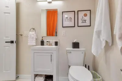 a bathroom with a white toilet and a sink at Backyard BBQ Retreat: Central 3bd - Prime Location in Arvada
