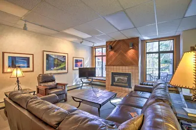 a living room with a leather couch and a fireplace at Convenient Winter Park Condo - 3 Mi to Resort! in Winter Park