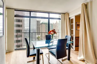 a dining room with a table and chairs and a large window at Downtown Denver Condo in the Center of the City! in Denver