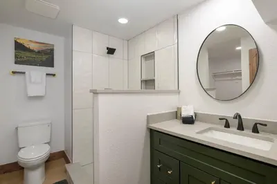 a bathroom with a sink and a toilet and a mirror at Modern luxury mountain house in Fraser