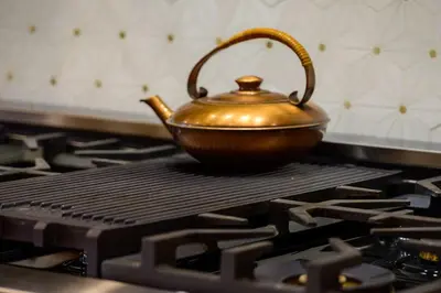 a golden tea kettle sitting on top of a stove at Luxury Mountain Retreat in Fraser