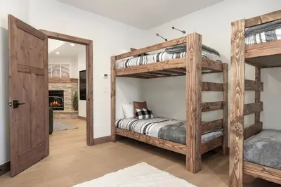 a bedroom with two bunk beds and a fireplace at Luxury Mountain Retreat in Fraser