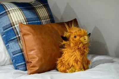 a stuffed dog sitting on a bed next to a pillow at Stylish Mountain getaway in Fraser