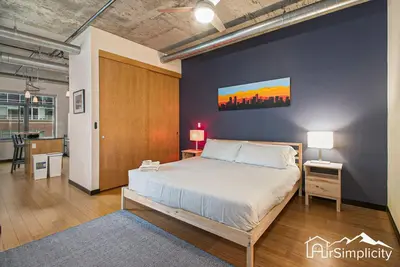 a bedroom with a bed and a blue wall at Condo w pvt balcony & gym access in Denver
