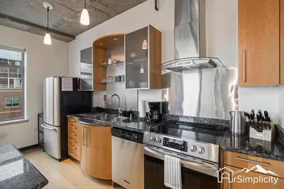 a kitchen with a stove and a stainless steel refrigerator at Condo w pvt balcony & gym access in Denver