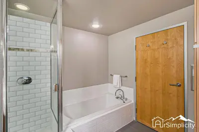 a white bathroom with a tub and a shower at Condo w pvt balcony & gym access in Denver