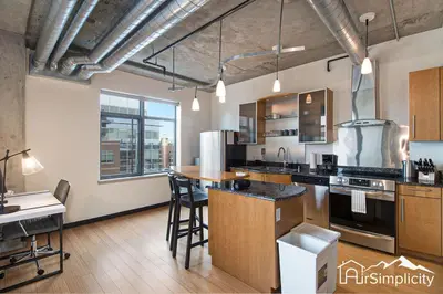 a large kitchen with a counter and a table at Condo w pvt balcony & gym access in Denver
