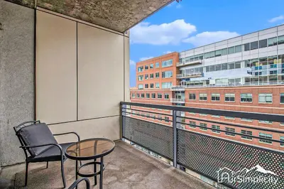 a balcony with a chair and a table and a building at Condo w pvt balcony & gym access in Denver