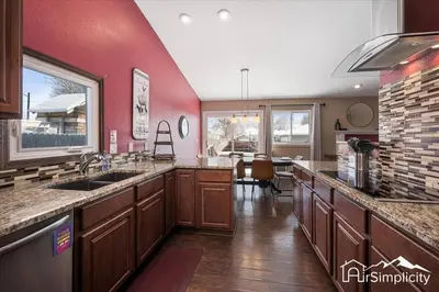 a kitchen with wooden cabinets and a red wall at Quiet Denver retreat w hot tub & fireplace in Denver