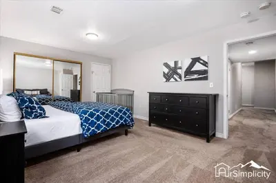 a bedroom with a bed and a dresser and a mirror at Quiet Denver retreat w hot tub & fireplace in Denver