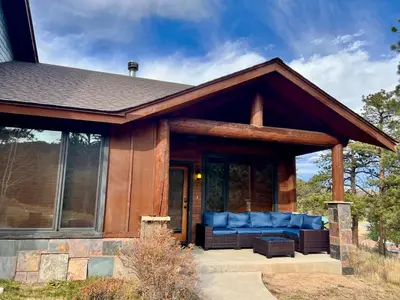 a house with a porch with a blue couch at Bears Den 1 - Hot Tub and Views! in Estes Park