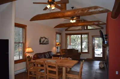 a living room with a table and a ceiling fan at Bears Den 1 - Hot Tub and Views! in Estes Park