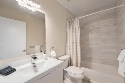 a white bathroom with a sink and a toilet at Walk to Broncos Stadium Hot tub & Rooftop in Denver