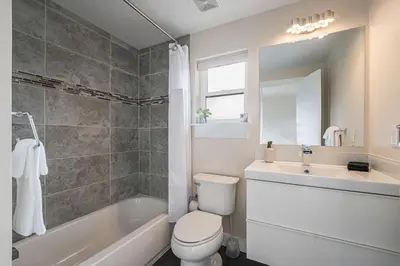 a bathroom with a toilet and a sink and a tub at Walk to Broncos Stadium Hot tub & Rooftop in Denver