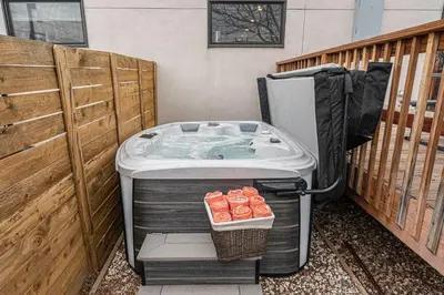 a hot tub sitting next to a wooden fence at Walk to Broncos Stadium Hot tub & Rooftop in Denver