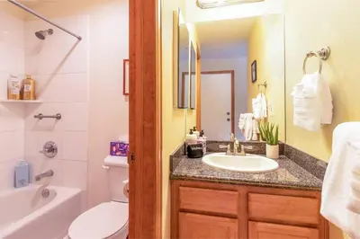 a bathroom with a sink and a toilet and a mirror at Cross Creek - Pool and Hot Tubs by Daniel in Frisco