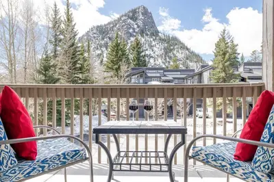 a balcony with a table and two chairs with wine glasses at Cross Creek - Pool and Hot Tubs by Daniel in Frisco