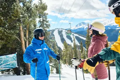 three people on a ski slope with a ski lift at Beautiful 2BR in River Run - Kids Ski Free! condo in Dillon