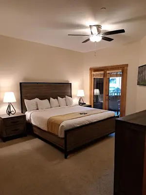a bedroom with a large bed with a ceiling fan at Beautiful 2BR in River Run - Kids Ski Free! condo in Dillon