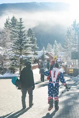 a group of people walking down a street carrying snowboards at Beautiful 2BR in River Run - Kids Ski Free! condo in Dillon