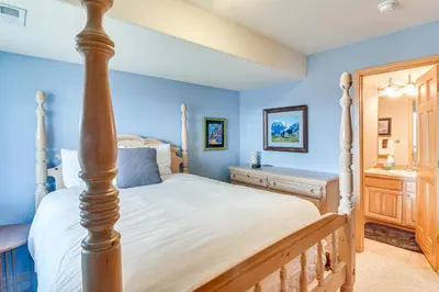 a bedroom with blue walls and a bed with a wooden post at 6 Mi to Skiing Mtn-View Fraser Duplex in Fraser