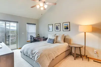 a bedroom with a bed with a table and a window at 6 Mi to Skiing Mtn-View Fraser Duplex in Fraser