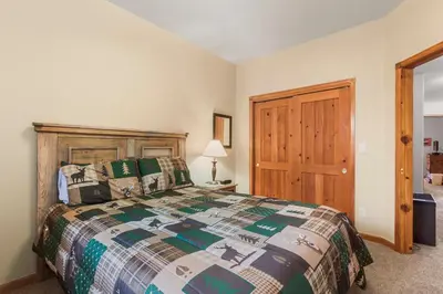 a bedroom with a bed and a wooden door at Lookout Ridge 45 by Great Western Lodging in Dillon