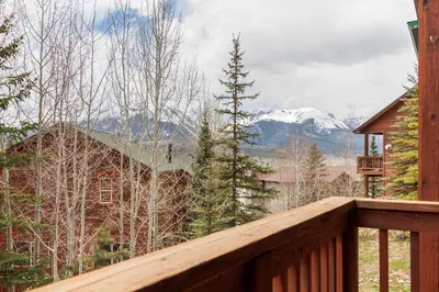 a wooden deck with a view of a snow covered mountain at Lookout Ridge 45 by Great Western Lodging in Dillon