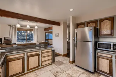 a kitchen with a stainless steel refrigerator and wooden cabinets at Mountain View Retreat home in Nederland