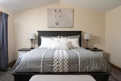 a bedroom with a bed with a horse picture on the wall at Mountain View Retreat home in Nederland